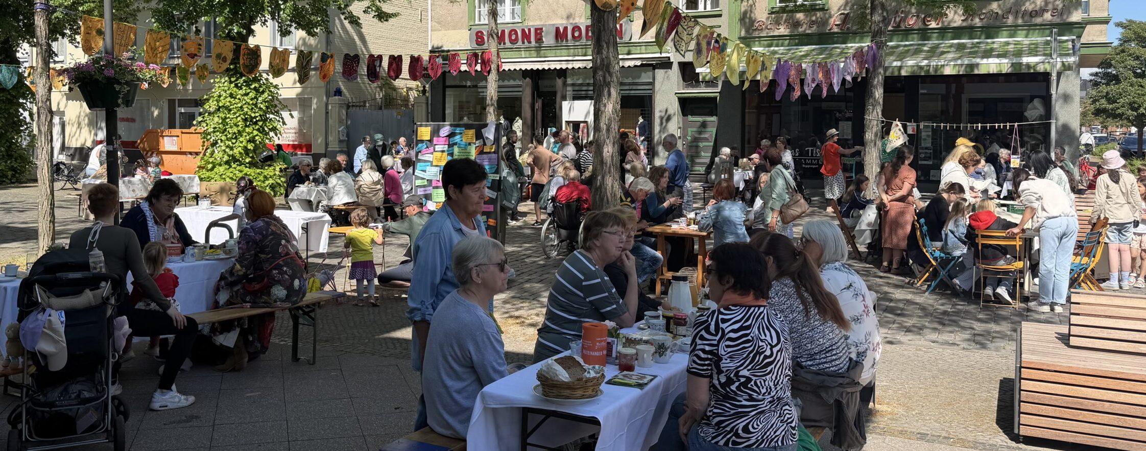 Menschen sitzen an Tischen und frühstücken gemeinsam. Foto: Katja Evertz